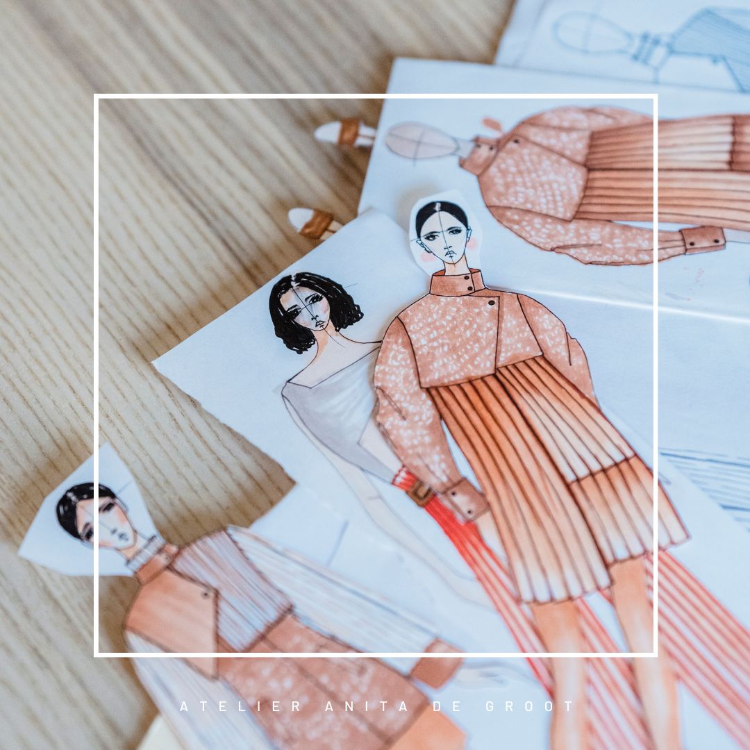 Modeschetsen van kledingontwerpen op een houten tafel